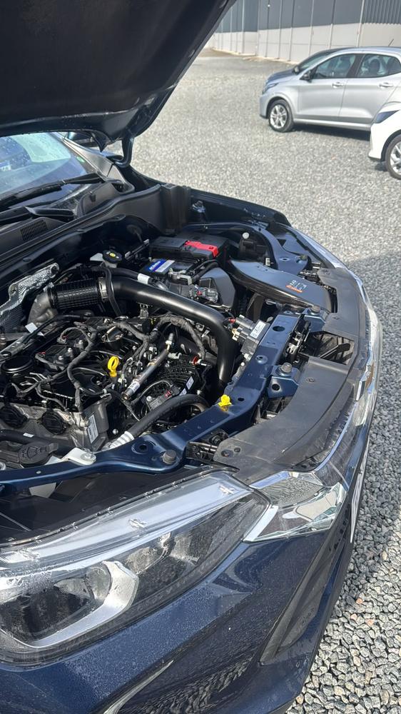Motor de um carro azul com o capô aberto